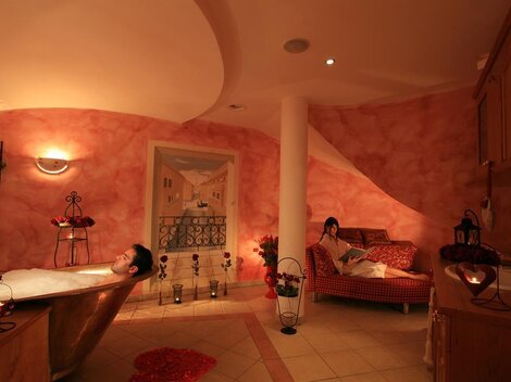 Ein entspannendes Badezimmer mit einer Badewanne und einer gemütlichen Couch. Sanftes Licht und warme Farben schaffen eine beruhigende Atmosphäre.