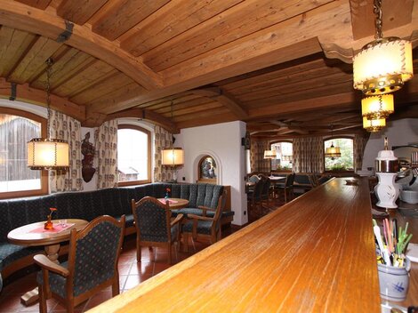 Ein gemütliches Restaurant mit Holzmöbeln und einer einladenden Atmosphäre. Die Fenster bieten einen Blick auf die Umgebung und die angenehme Beleuchtung sorgt für eine warme Stimmung.