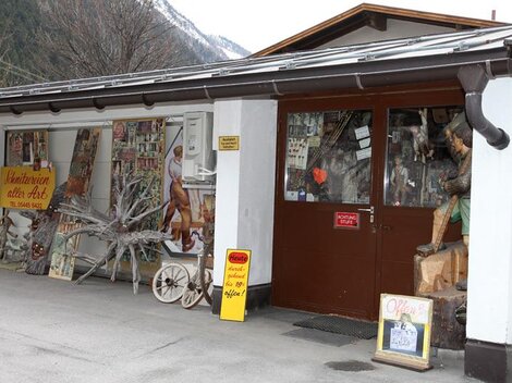Ein traditionelles Geschäft mit Holzschnitzereien und Kunsthandwerk. Die Fassade zeigt verschiedene Kunstwerke und eine einladende Eingangstür.