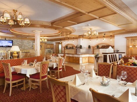 Ein elegantes Restaurant mit holzverkleideten Wänden und gemütlichen Tischen. Die Atmosphäre ist warm und einladend, ideal für ein schmackhaftes Essen.