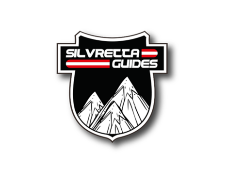 Ein Logo mit dem Namen "Silvretta Guides". Es zeigt stilisierte Berge auf einem schwarzen Schild.