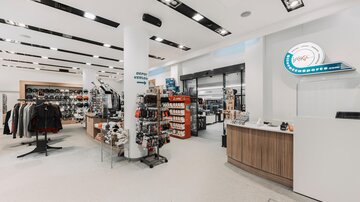 A modern retail space with clothing and accessories. The displays are neatly arranged, and the walls are brightly designed.