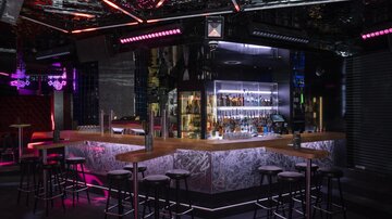 Eine stilvolle Bar mit moderner Beleuchtung und einer großen Auswahl an Getränken. Die Einrichtung ist elegant und einladend.