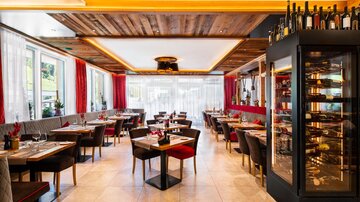 A modern restaurant with elegant decor and cozy tables. Large windows provide plenty of light and an inviting atmosphere.