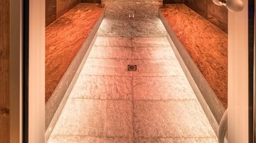 A modern steam bath with stone benches and soft lighting. The room radiates relaxation and well-being.