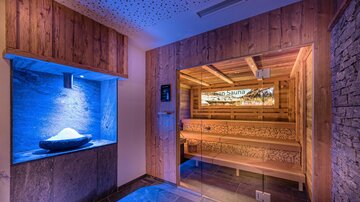 A stylish wellness area with a wood sauna and soft blue lights. The relaxing atmosphere invites you to linger.