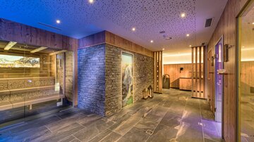 A stylish wellness area with wood and stone details. Soft lighting creates a relaxing atmosphere.