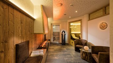 A cozy wellness area with warm lighting and wood paneling. Comfortable seating invites relaxation.