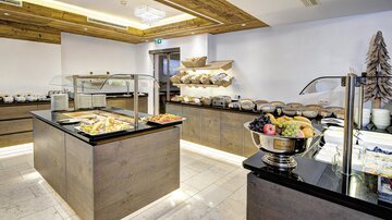 Ein eleganter Frühstücksbereich mit verschiedenen Speisen und frischem Obst. Die Anlage ist modern und gut organisiert, ideal für eine angenehme Mahlzeit.
