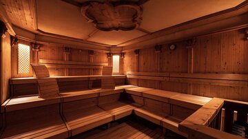 Ein gemütlicher Saunaraum mit Holzverkleidung und Sitzbänken. Das warme Licht schafft eine entspannende Atmosphäre.
