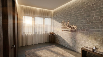 Ein moderner Raum mit Backsteinwand und großen Fenstern, die Licht hereinlassen. An der Wand steht das Wort "Sky Balance" in eleganter Schrift.