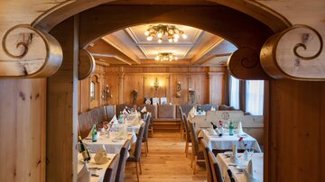 Ein gemütliches Restaurant mit Holzdekor und elegant eingedeckten Tischen. Die Atmosphäre ist warm und einladend.