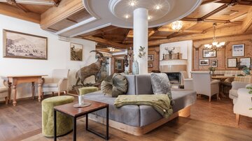 A cozy living area with wooden ceiling and modern furniture. The room is stylishly decorated and conveys an inviting atmosphere.