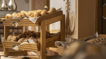 A wooden frame with various rolls and bread. Decorative elements are visible in the background.